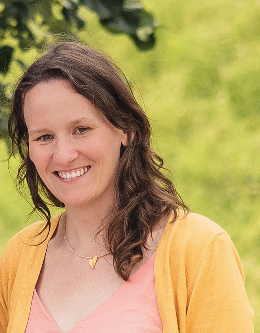 Johanna, lachend im gelben Oberteil im Garten
