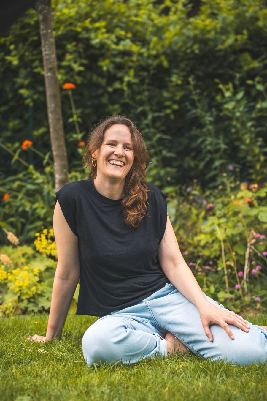 Portrait von Johanna, lachend im Garten sitzend